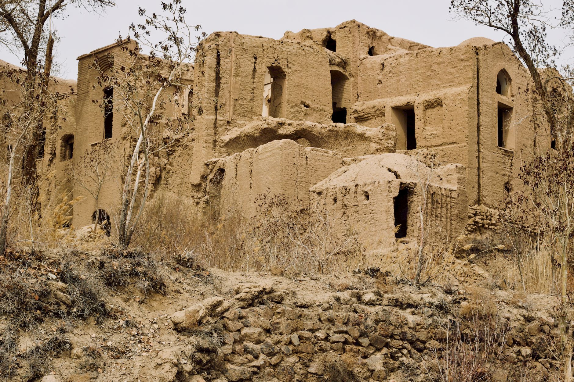 Adobe mud-brick citadel ruins in a desert landscape, the kind of structure destroyed at Bam in 2003